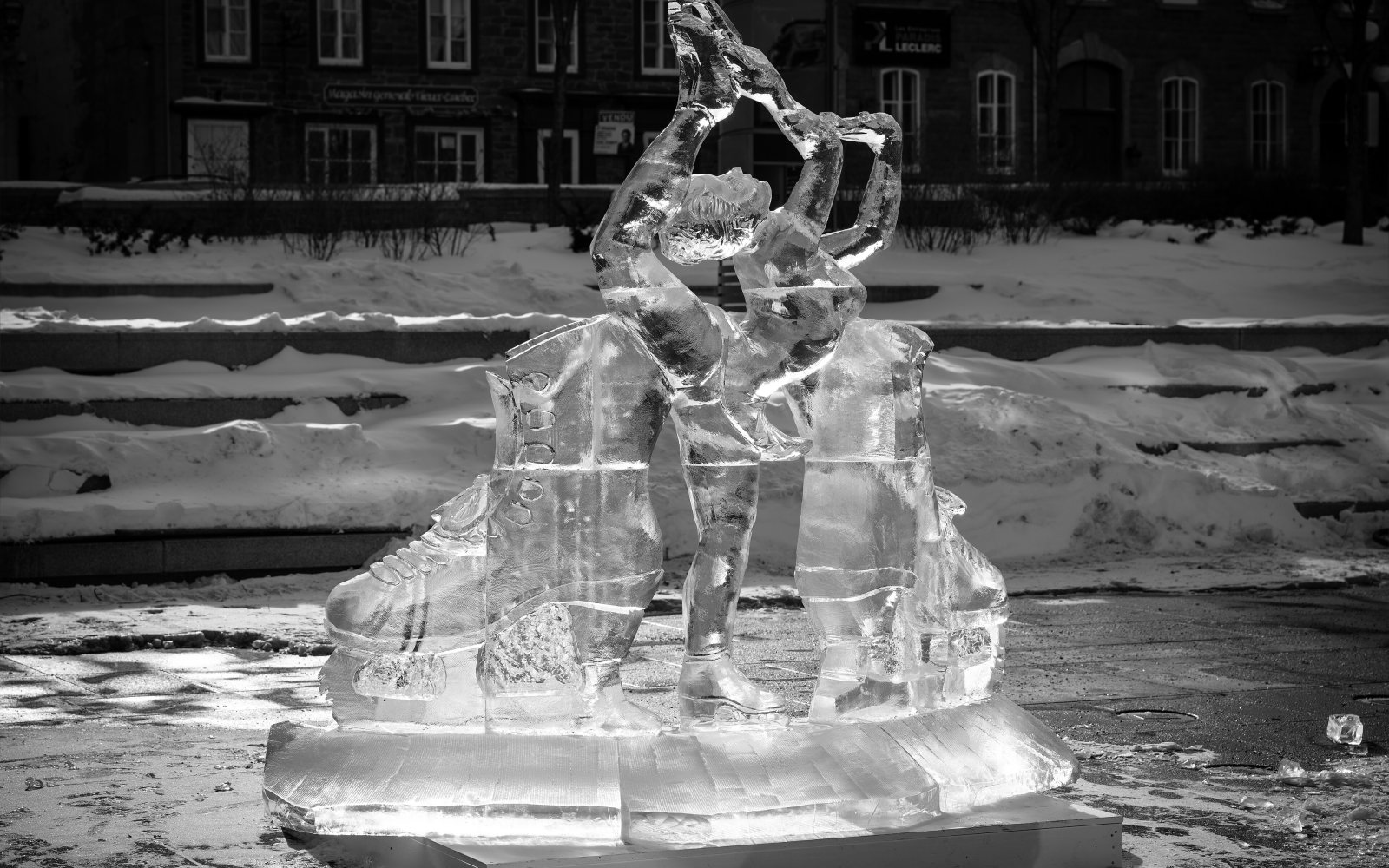 A carved ice sculpture lit at night on a city street