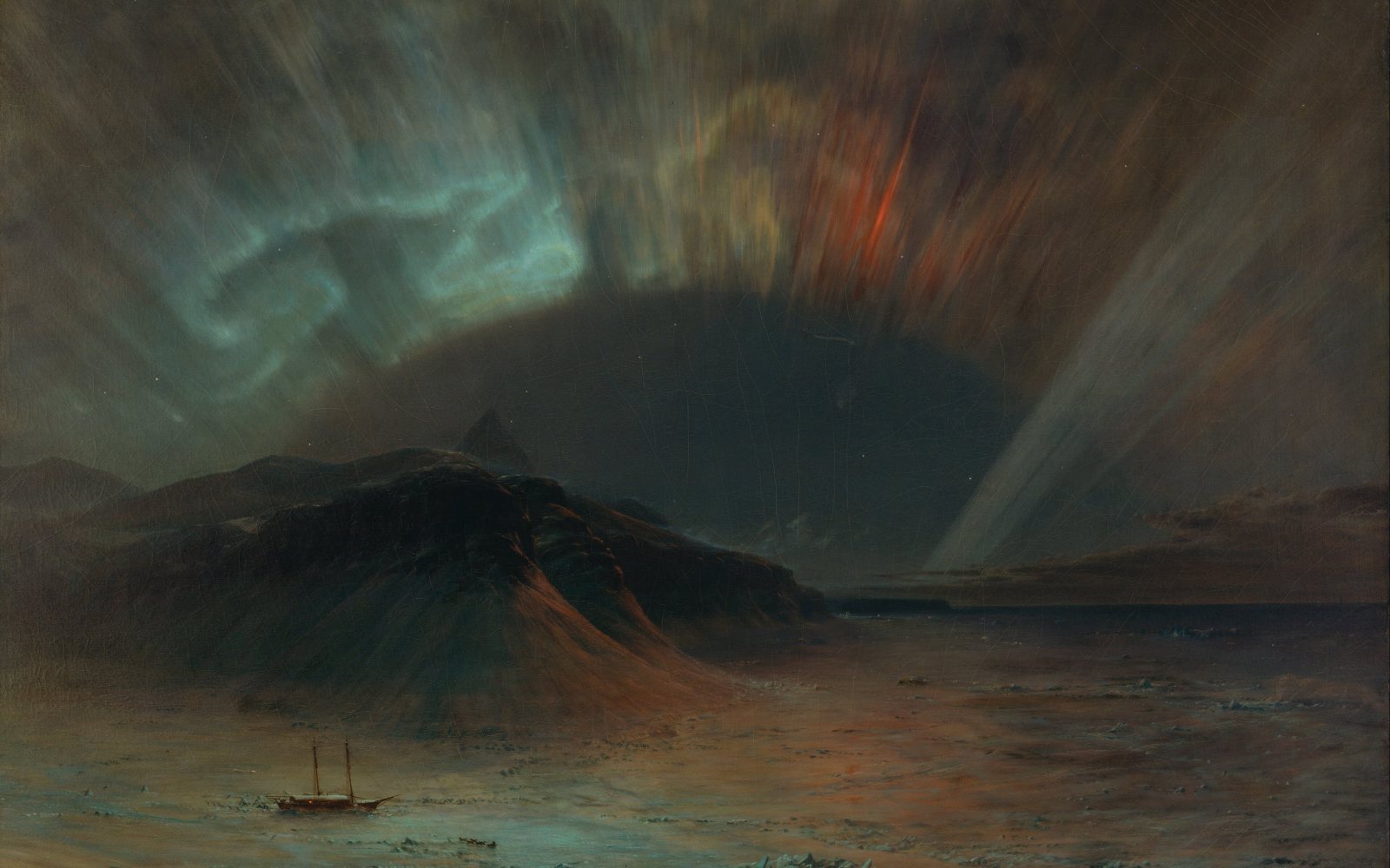 Green northern lights glowing over a dark landscape