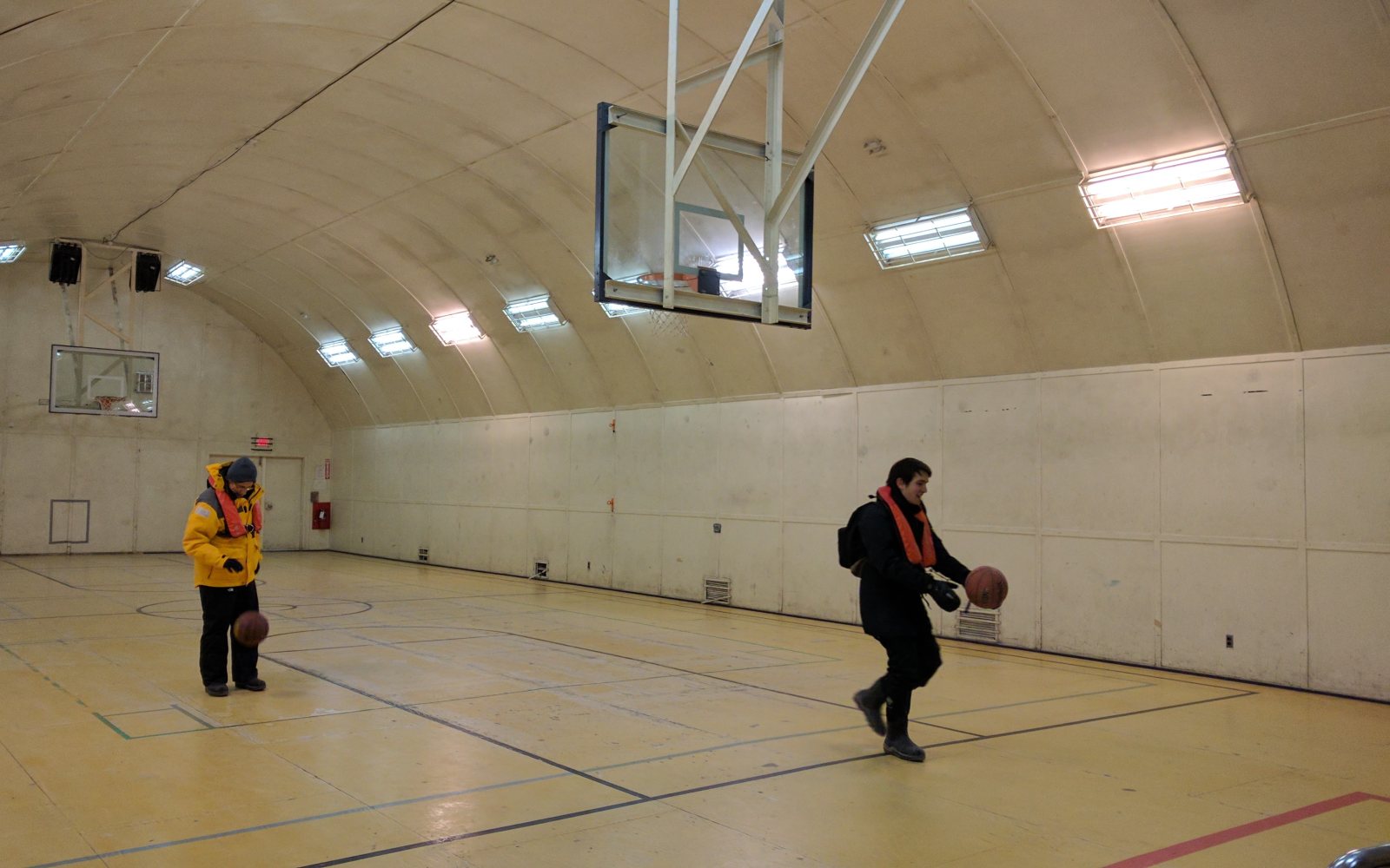 A basketball hoop in a high school gymnasium